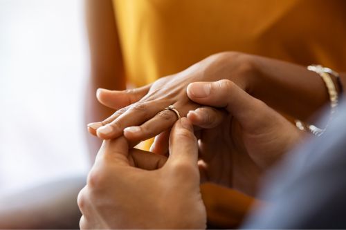 A wedding ring being placed on a woman's finger